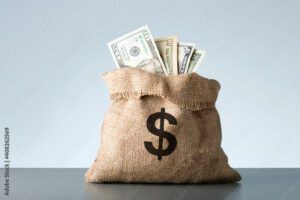 Burlap with dollar banknotes on gray background. Bribe or bonus concept.